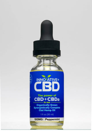 Bottle of Innovative CBD oil with a dropper on a light gray background