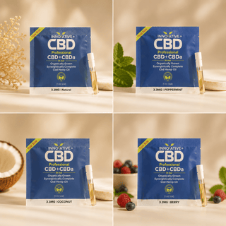 nnovative CBD 100mg trial size CBD + CBDa tincture pouches with 1ml glass vials in Natural, Peppermint, Coconut, and Berry flavors on a soft neutral luxury wellness background.