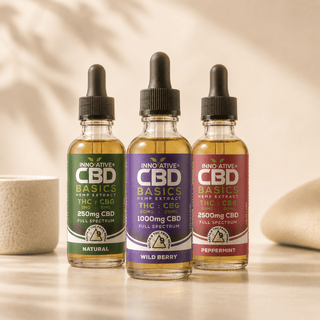 Innovative CBD Basics Full Spectrum CBD tinctures featuring Natural 250mg, Wild Berry 1000mg, and Peppermint 2500mg bottles in a premium luxury wellness editorial setting with soft neutral lighting and modern apothecary aesthetic.