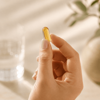 “Hand holding a golden full spectrum CBD capsule in soft natural morning light with a premium wellness aesthetic.”