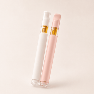 Premium full spectrum CBD vape pens in soft blush pink and matte white with minimalist luxury wellness styling on a warm cream background.