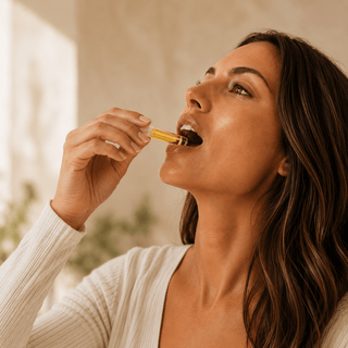 Woman using Innovative CBD trial size 1ml hemp oil vial with golden CBD + CBDa oil in a warm neutral luxury wellness setting.