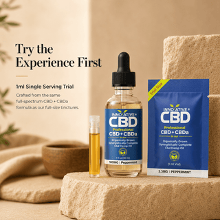 Innovative CBD peppermint full spectrum CBD + CBDa 100mg tincture bottle beside 1ml single serving trial vial and trial pouch on a warm neutral luxury wellness background with “Try the Experience First” text.