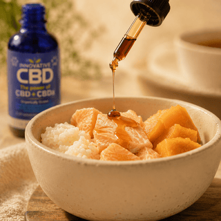 Dark amber full spectrum CBD and CBDa hemp oil drizzled onto fresh pet food with salmon, rice, and pumpkin in a luxury ceramic bowl beside Innovative CBD pet tincture.
